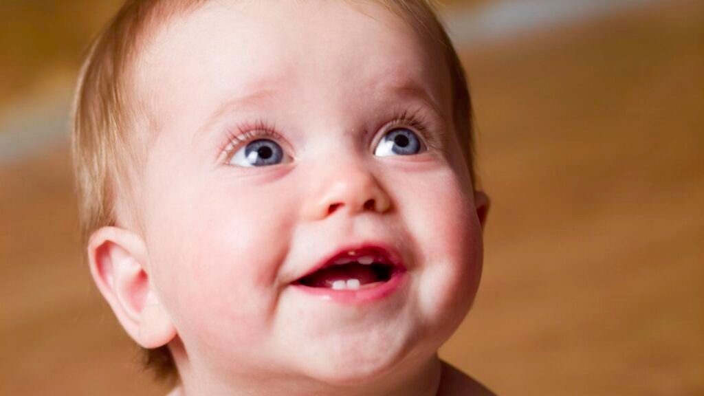 Smiling toddler holding a toothbrush during their first dental check-up